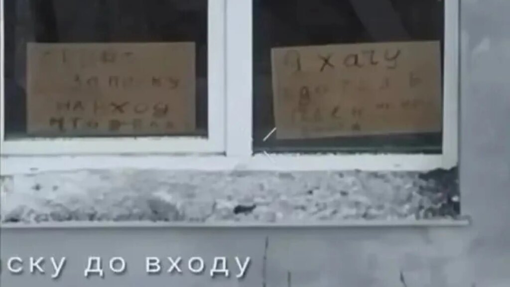 Soldado ruso con cartón 'Quiero vivir' en edificio de Járkov durante la guerra