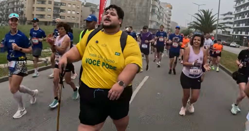 Influencer brasileño sonriendo con su bastón tras completar el maratón