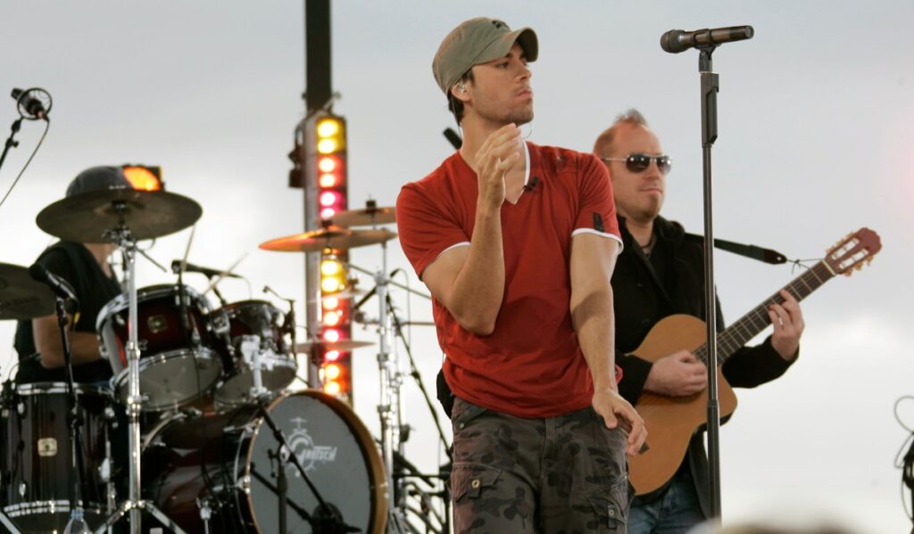 Enrique Iglesias en concierto con fan subiendo al escenario para besarlo