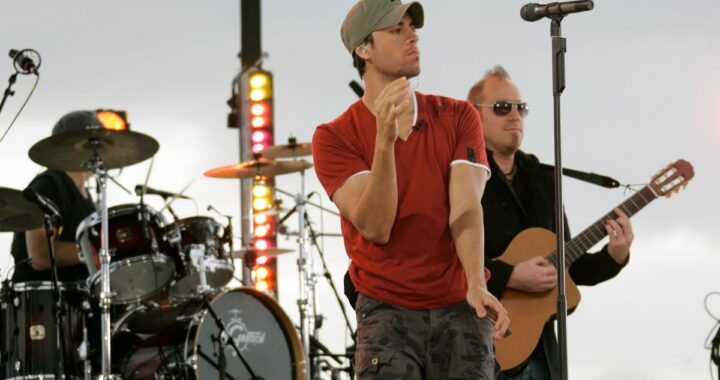 Enrique Iglesias en concierto con fan subiendo al escenario para besarlo