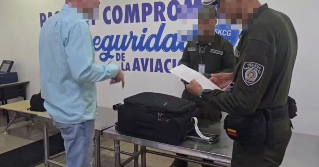 Imagen de un aeropuerto con un policía revisando una maleta