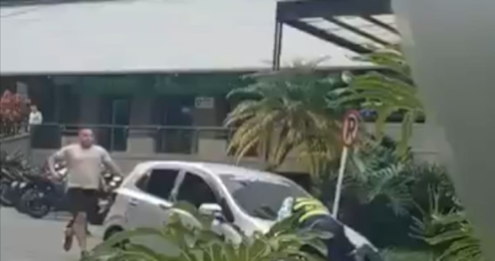 Imagen de un vehículo en movimiento con un agente de tránsito sobre el capó