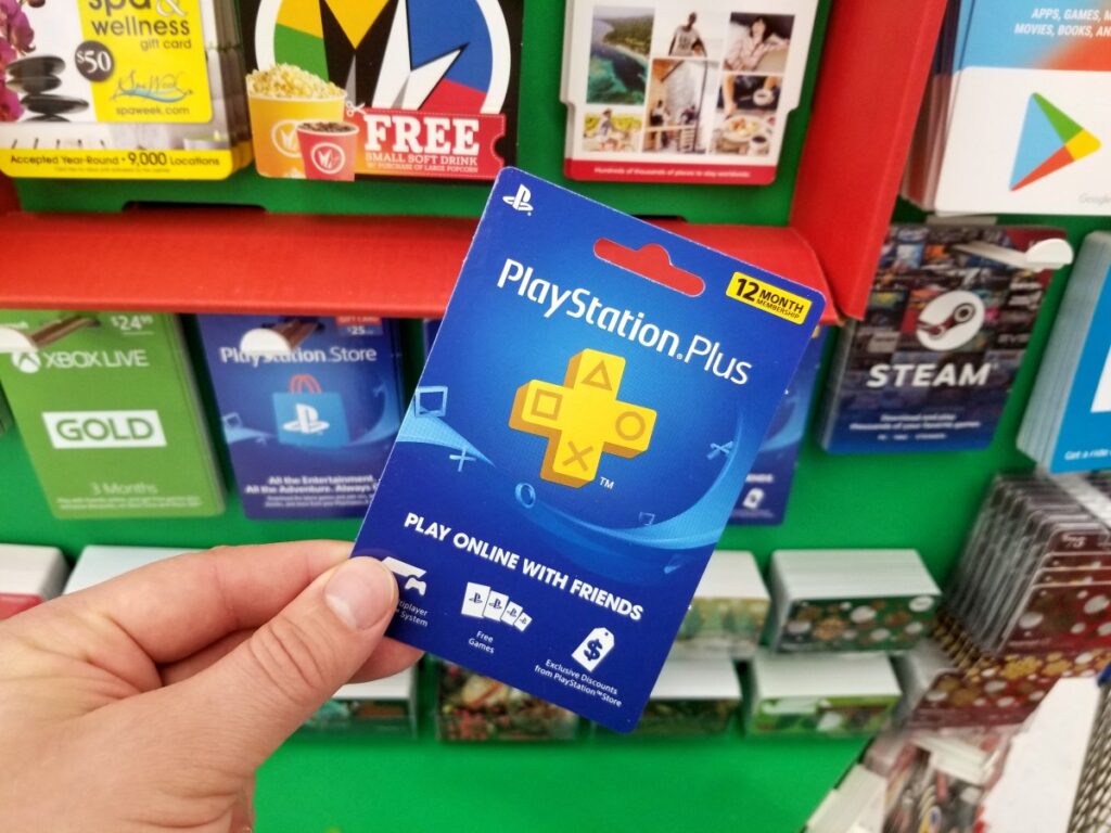 Un hombre sostiene un controlador de PlayStation con una imagen de una gráfica de precios en el fondo