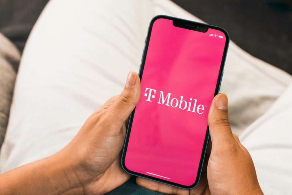 Una mano sostiene un smartphone con una tarjeta eSIM en la pantalla, con un estadio de fútbol al fondo
