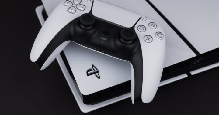 Imagen de una PS5 con una pantalla de Linux en el televisor, con un mando de juego en primer plano