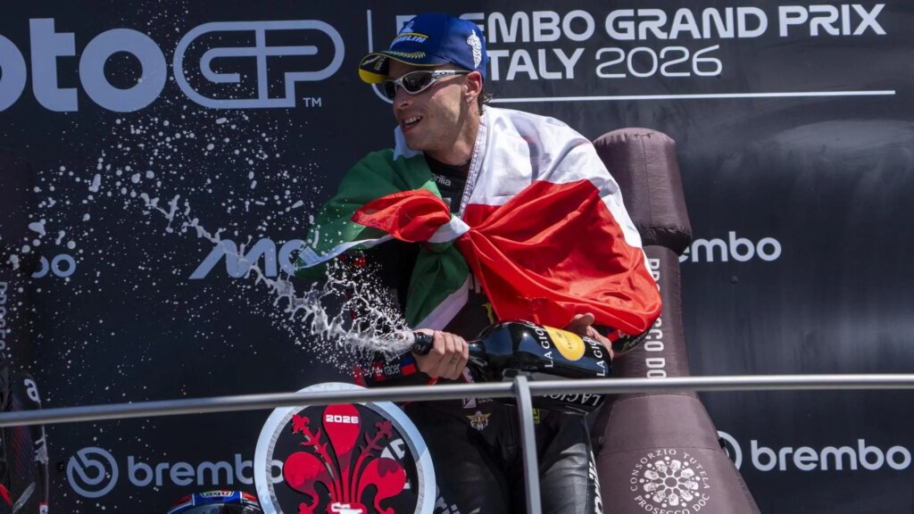 Marco Bezzecchi llorando en el podio de Mugello tras su victoria histórica con la Aprilia, rodeado de multitudes