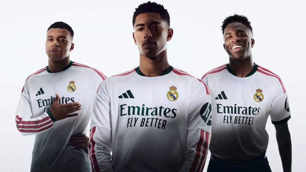 Primera camiseta rosa y verde del Real Madrid 2026-2027 con detalles geométricos inspirados en su escudo, sobre maniquí en el Bernabéu