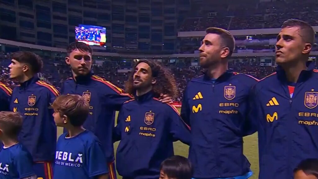 Jugadores de la selección española sonriendo durante el himno largo en el estadio de Puebla