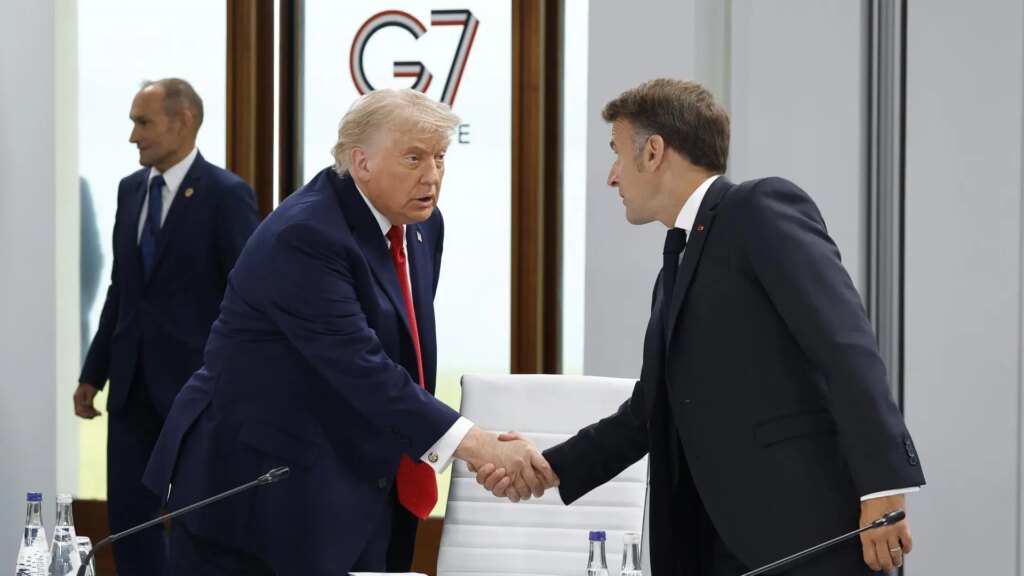 Donald Trump en un discurso firme con gesto serio, fondo de bandera estadounidense