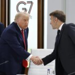 Donald Trump en un discurso firme con gesto serio, fondo de bandera estadounidense