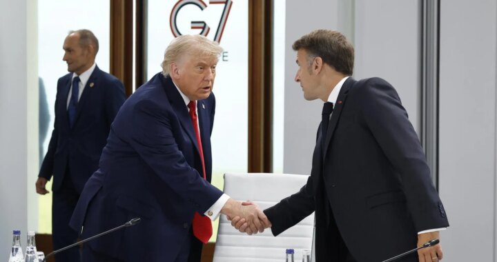 Donald Trump en un discurso firme con gesto serio, fondo de bandera estadounidense