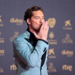 David Bisbal sonríe en el plató de 'Operación Triunfo' como jurado, con micrófono y fondo de escenario iluminado