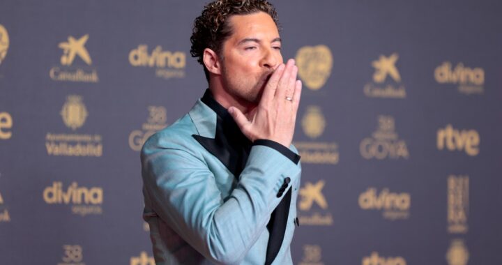 David Bisbal sonríe en el plató de 'Operación Triunfo' como jurado, con micrófono y fondo de escenario iluminado