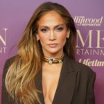 Jennifer Lopez sonríe en el set de 'Office Romance' con fondo de cine clásico