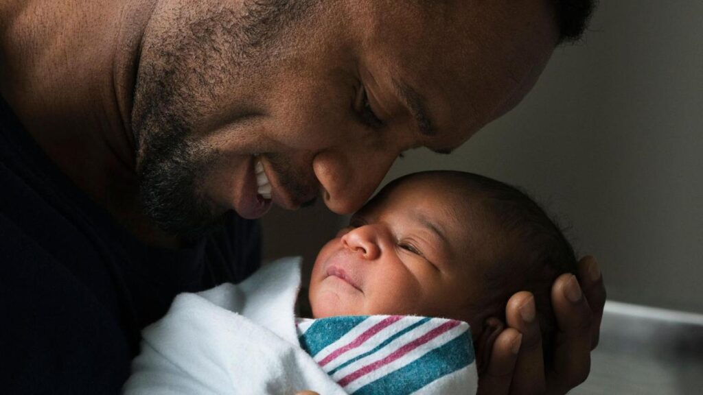 Padre con bebé en brazos mostrando conexión emocional y cambios biológicos por paternidad