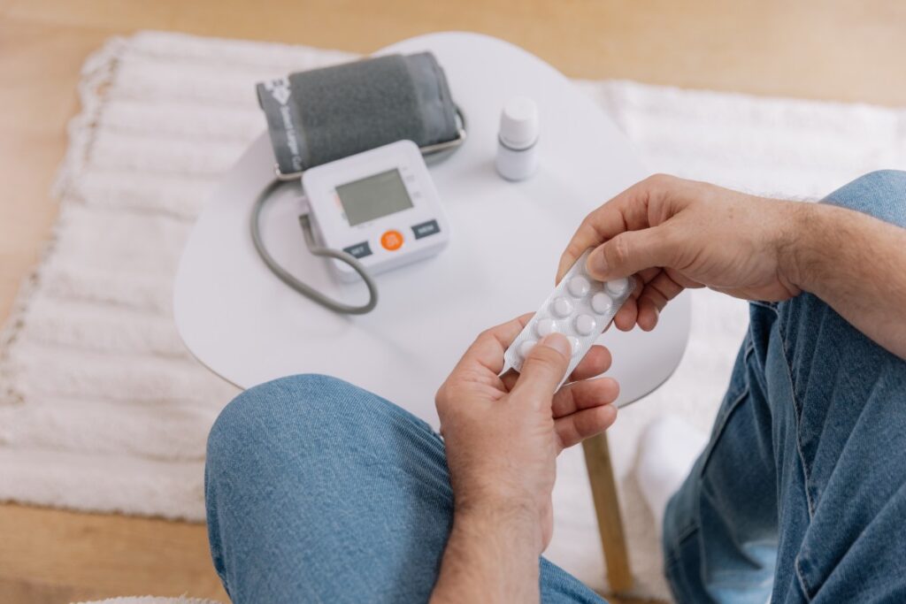 Paciente revisando pastillas para la presión arterial con expresión de preocupación