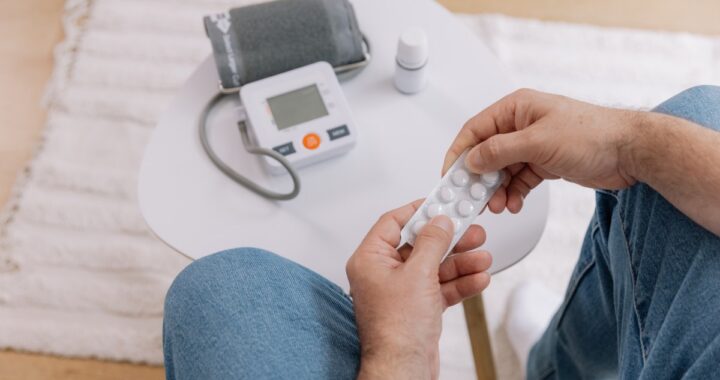 Paciente revisando pastillas para la presión arterial con expresión de preocupación
