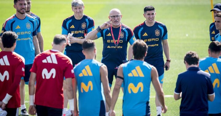 Lamine Yamal en entrenamiento con España 2026, sonriendo junto a Rodri y Gavi en un campo de fútbol con la bandera nacional