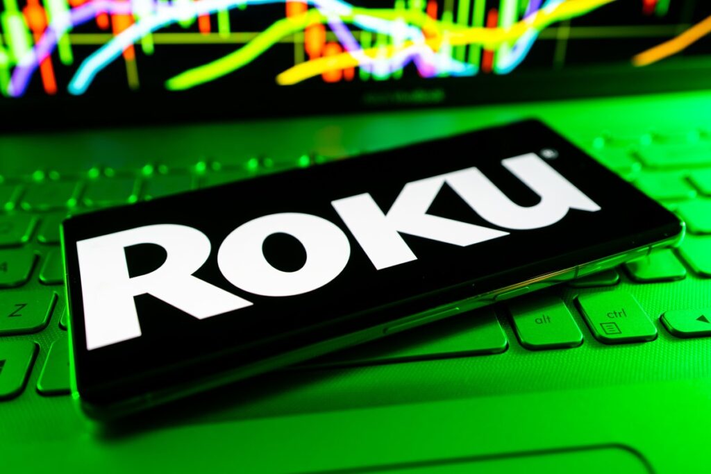 Logos de Fox y Roku fusionados sobre fondo de pantalla de streaming con gráficos de crecimiento