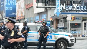 Policías de Nueva York coordinando seguridad en evento masivo con multitudes al fondo
