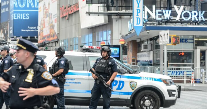 Policías de Nueva York coordinando seguridad en evento masivo con multitudes al fondo