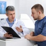 Médico revisando análisis de sangre y gráficos de salud para chequeos después de los 40
