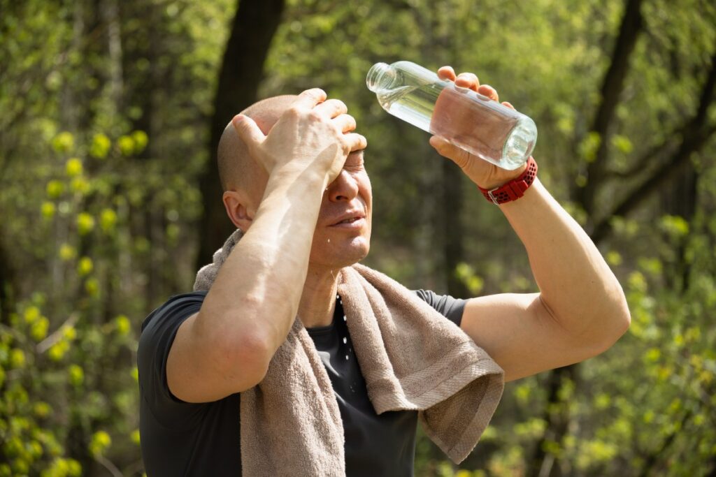 Persona bebiendo agua fresca en un día de calor extremo para evitar deshidratación