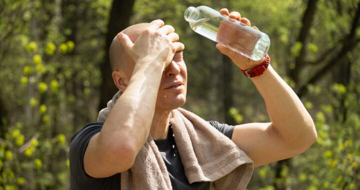 Persona bebiendo agua fresca en un día de calor extremo para evitar deshidratación
