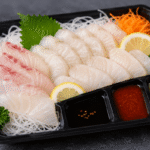 Sashimi coreano en bandeja con sobres de condimentos y etiquetas de alérgenos