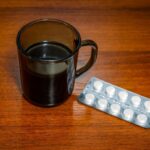 Taza de café junto a pastillas y gráfico de interacciones farmacológicas