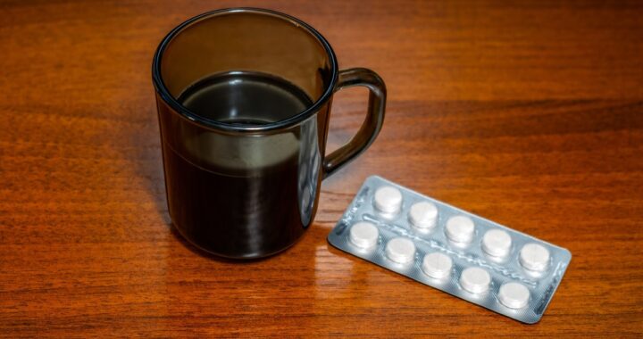 Taza de café junto a pastillas y gráfico de interacciones farmacológicas